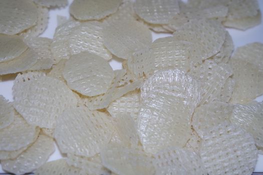 Closeup view with selective focus on dried chips as fast food for tea break. Potato chips with spices sprinkled on it. Fast food background for advertisements.