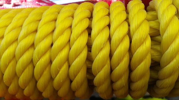 Closeup of bright color braided plastic ropes. Hanks or coil of bright colored plastic rope interwoven which are used for climbing and tightening materials.
