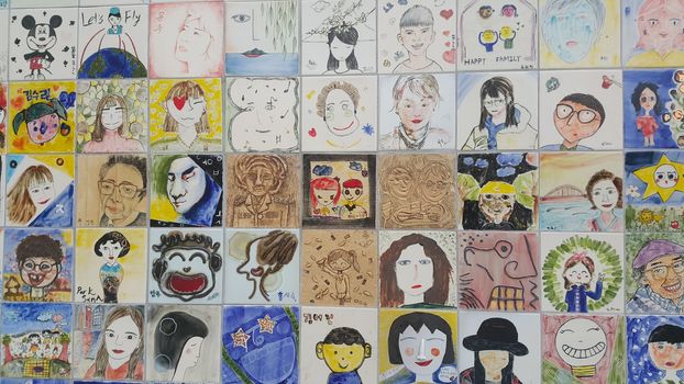 Chuncheon city hall, South Korea-March-25, 2019: Paintings and sculpted faces of people on the concrete wall for memoir in a public park.