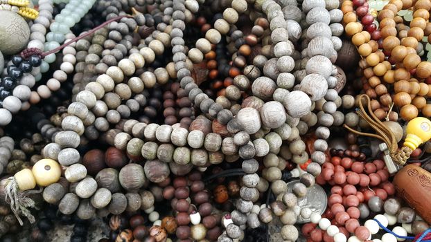 Beautiful wooden prayer beads or rosary placed over fabric background. Religion concept of ramadan or Eid for muslims.