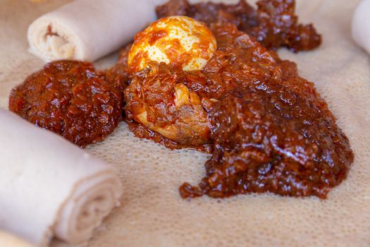 Injera served with Chicken and egg Doro Wat.  Injera is a sourdough flatbread made from teff flour.  It is the national dish of Ethiopia, Eritrea, Somalia and Djibouti