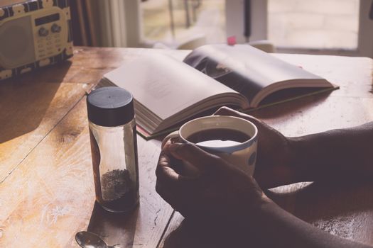 Tranquil scene of black person drinking coffee in the kitchen