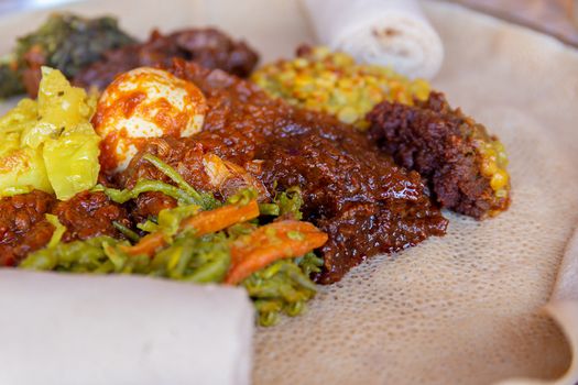 Injera served with Chicken and egg Doro Wat, berbere, vegetables and lentils.  Injera, the national dish of Ethiopia, is a sourdough flatbread made from teff flour.