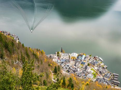 Bird‘s-eye view from the World Heritage Observation Point on Hallstatt Village in Austria with a ship arriving from the train station across the lake.