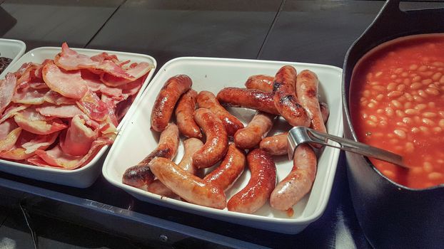 English breakfast buffet with bacon, sausages and baked beans
