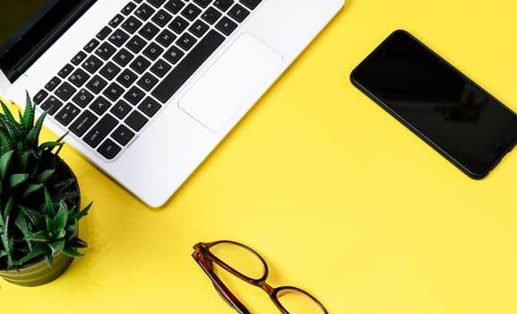 Laptop placed on a yellow table background of business working place with cup coffee, Empty workspace