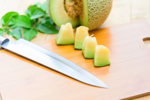 Fresh green melon on wood plate