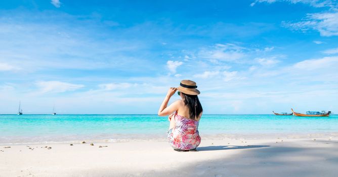 Women sitting back on the beach and sea have a holiday summer relaxing and travel bright sky koh lipe thailand