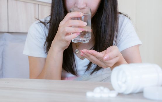 Flu medicine woman Infected With Cold the drug is placed on the table and a glass of water.