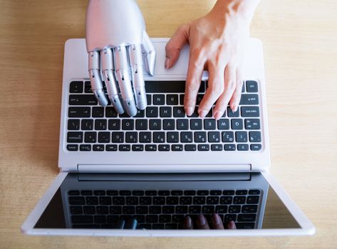 Robot hands and fingers point to laptop button advisor chatbot robotic artificial intelligence concept