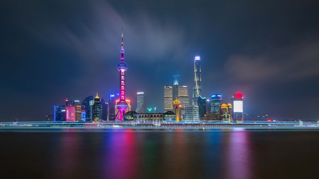 Shanghai city skyline Pudong side looking through Huangpu river on twilight time. Shanghai, China. Beautiful vibrant panoramic image.