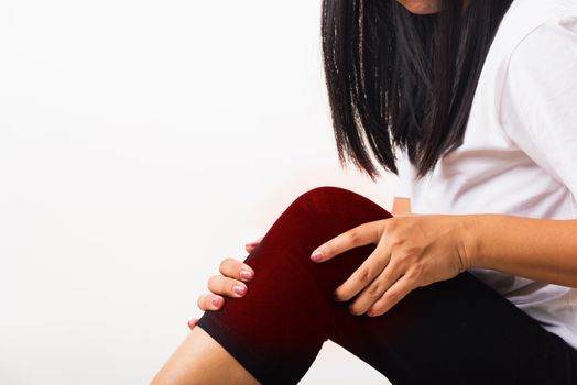 Closeup young woman aches to suffer from pain knee and she uses hand joint hold knee agony, studio shot isolated on white background Rheumatism healthcare and medical physiotherapy therapy concept