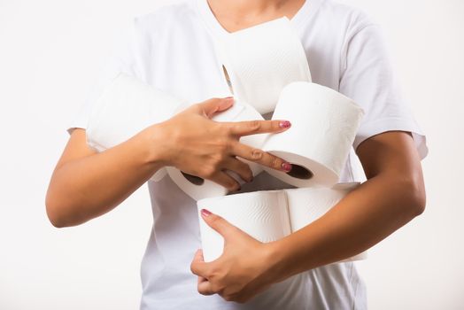 Closeup Asian young woman stocking up toilet paper for home panic in stores quarantine from coronavirus. Female holding many rolls of toilet paper in arms on chest, studio isolated on white background