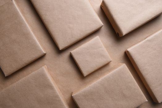 Closeup of a group of plain paper packages. The parcels are blank and on the same color background.