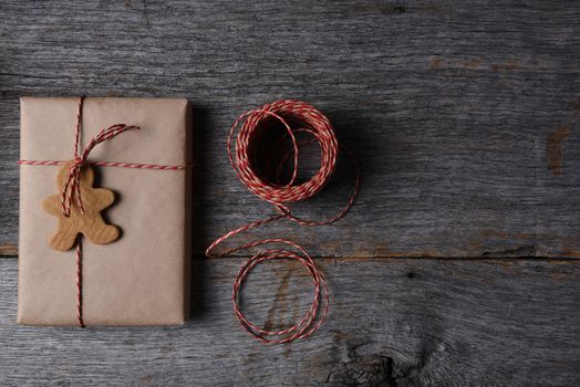 High angle shot of a Christmas Present with a Holiday Shaped Cookie, twine and copy space.