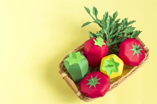 Colorful paper tomatoes, peppers and parsley in wicker tray. Real volumetric handmade paper objects. Paper art and craft