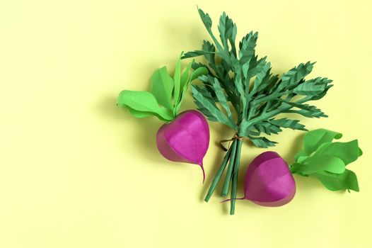Colorful radish and parsley made from paper on yellow background. Real volumetric handmade paper objects. Paper art and craft