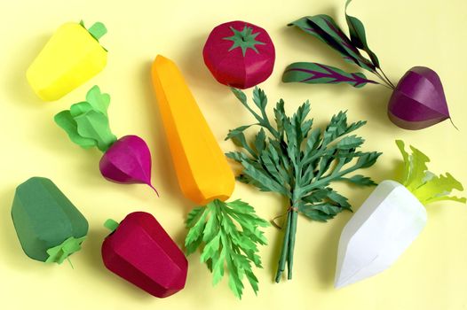 Colorful set of paper vegetables on yellow background. Real volumetric handmade paper objects. Paper art and craft