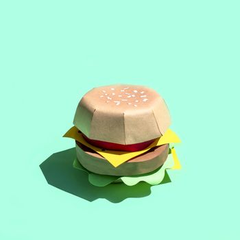 Hamburger made of paper. Volumetric handmade paper objects. Paper art and craft. Trendy hobby. Minimal artistic food concept. Copy space