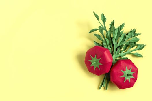 Two paper tomatoes and parsley on yellow background. Real volumetric handmade paper objects. Paper art and craft