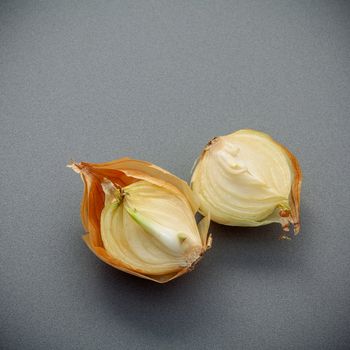 Raw bulbs of onion on gray background flat lay and copy space. top view