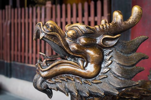 Golden color dragon head scultpure in a buddhist temple, China