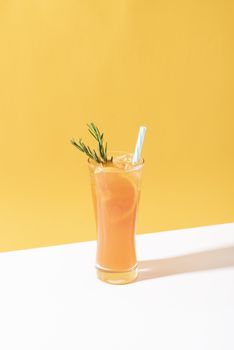 Cold and refreshing orange punch cocktail with orange slice on yellow background. summer drink.