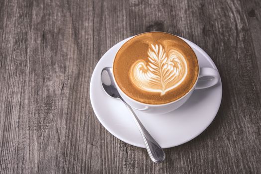 latte or Cappuccino with frothy foam, coffee cup top view on table in cafe.