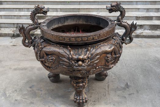 Bronze incense burner in a chinese temple with dragon decorations