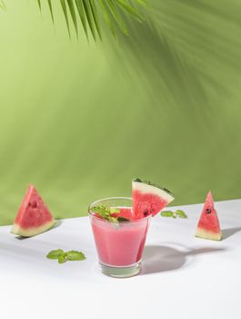 Fresh water melon juice and watermelon slice on green background. summer drink.