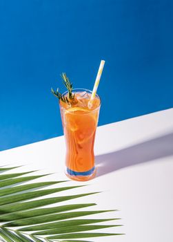 Cold and refreshing orange punch cocktail with orange slice on blue background. summer drink.