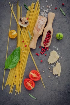 Italian food concept. Spaghetti with ingredients sweet basil ,tomato ,garlic peppercorn ,champignon,zucchini and parmesan cheese on dark background flat lay and copy space.