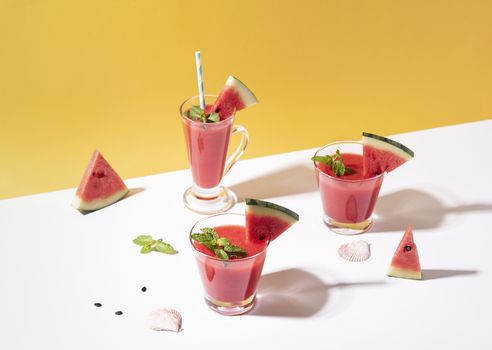 Fresh water melon juice and watermelon slice on yellow background. summer drink.