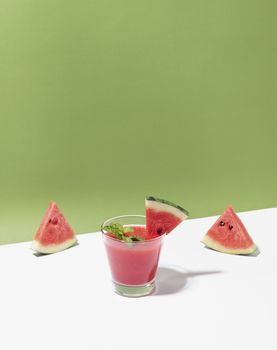 Fresh water melon juice and watermelon slice on color background. summer drink.