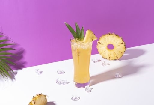 iced pineapple punch cocktail in glass on color background. summer drink.