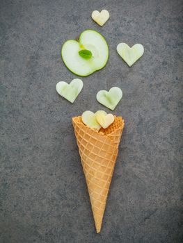 Apple slice in waffle cones and heart shape of apple setup on dark stone background . Valentine 's day and Sweet menu concept.