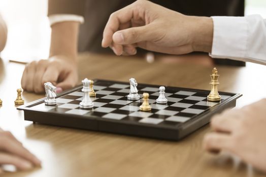 Collaborative process of skilled person brainstorming play chess game in office.