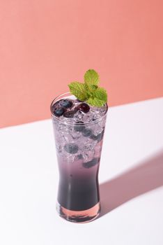 Cold and refreshing  blueberry punch cocktail with mint on color background. summer drink