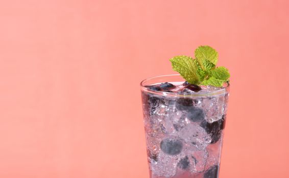 Cold and refreshing  blueberry punch cocktail with mint on color background. summer drink