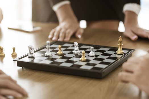 Collaborative process of skilled person brainstorming play chess game in office.