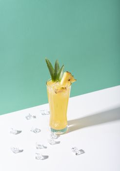 iced pineapple punch cocktail in glass on color background. summer drink.