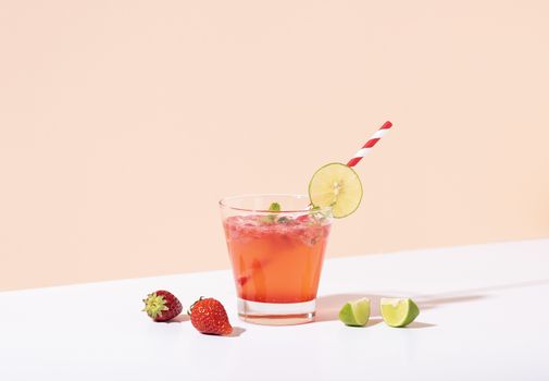 iced strawberry punch cocktail in glass with lemon on color background. summer drink.