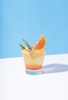 Cold and refreshing orange punch cocktail with orange slice on color background. summer drink.