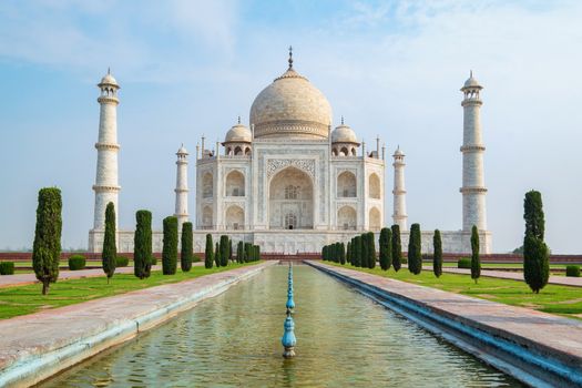 Taj Mahal front view reflected on the reflection pool, an ivory-white marble mausoleum on the south bank of the Yamuna river in Agra, Uttar Pradesh, India. One of the seven wonders of the world.