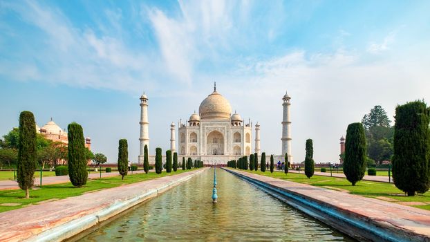 Taj Mahal front view reflected on the reflection pool, an ivory-white marble mausoleum on the south bank of the Yamuna river in Agra, Uttar Pradesh, India. One of the seven wonders of the world.