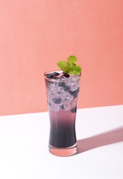 Cold and refreshing  blueberry punch cocktail with mint on color background. summer drink