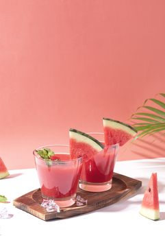 Fresh water melon juice and watermelon slice on red background. summer drink.