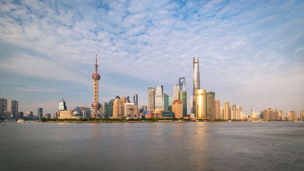 Shanghai city skyline Pudong side looking through Huangpu river on a sunny day. Shanghai, Chima. Beutiful vibrant panoramic image.