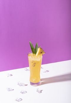 iced pineapple punch cocktail in glass on color background. summer drink.