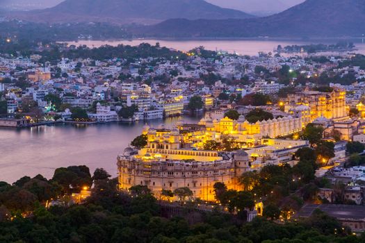 Udaipur city at lake Pichola in the evening, Rajasthan, India. View from  the mountain viewpoint see the whole city reflected on the lake.